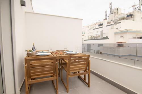 a table and two chairs in a room with a building at Flat with Balcony near Casino by HostWise in Monte Gordo