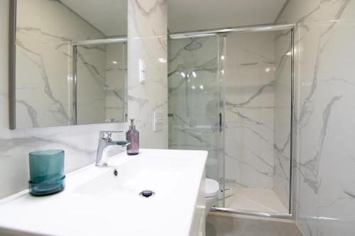 a bathroom with a sink and a shower at Flat with Balcony near Casino by HostWise in Monte Gordo