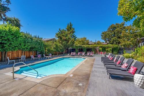 a swimming pool with chaises and chairs in a yard at White House Napa in Napa