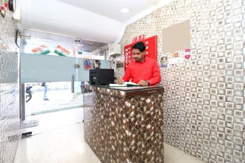 a man standing at a counter in a store at Hotel O Heaven in Ambāla