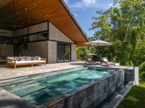 an outdoor swimming pool with a house at Mandala Ojochal Boutique Resort & Retreat Center in Ojochal