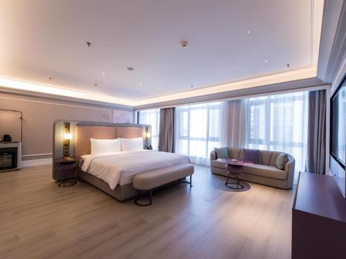a bedroom with a bed and a couch and a bed and a room with at Mercure Hotel Changchun Hengxing in Changchun