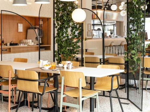 a dining room with two tables and chairs at ibis Styles Paris Romainville in Romainville