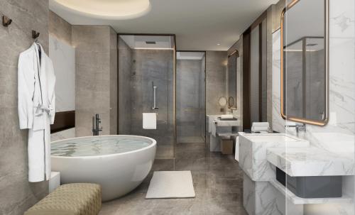 a bathroom with a large tub and two sinks at Crowne Plaza Weihai Binhai by IHG in Weihai