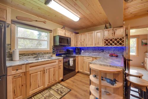 a large kitchen with wooden cabinets and a window at Big Fish Bay Hideaway - Rice Lake Home with Dock! in Rice Lake