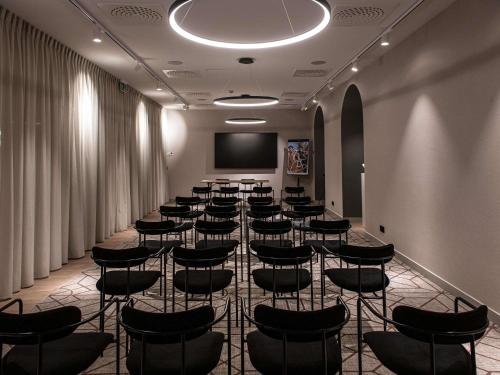 a conference room with chairs and a projection screen at Mercure Liege City Centre in Liège