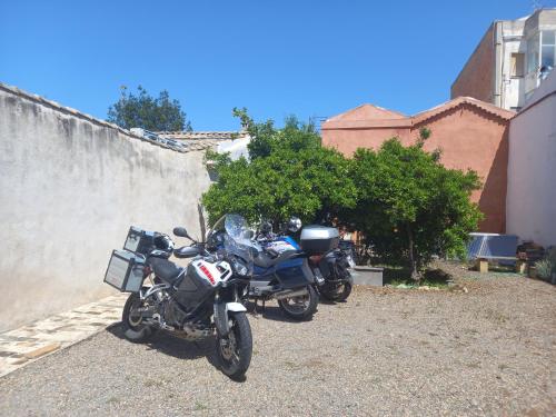 two motorcycles are parked next to a wall at Oasi Ottocento in Quartu SantʼElena