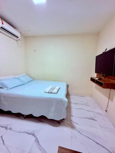 a room with a bed and a flat screen tv at FLAT -Apartamento na Pedreira Belém in Belém