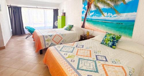 a bedroom with two beds and a painting on the wall at Cancun Studio - Steps to Beach and Water Fun in Cancún