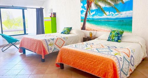 two beds in a room with a view of the beach at Cancun Studio - Steps to Beach and Water Fun in Cancún