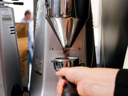 a person is holding a mixer in a machine at Novotel Perth Murray Street in Perth
