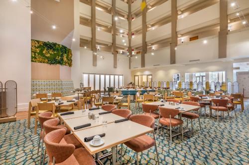a large dining room with tables and chairs at Holiday Inn Orlando – Disney Springs® Area by IHG in Orlando
