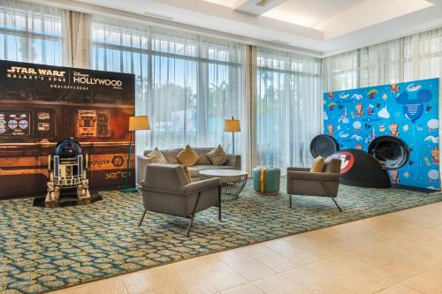 a hotel lobby with chairs and a large window at Holiday Inn Orlando – Disney Springs® Area by IHG in Orlando