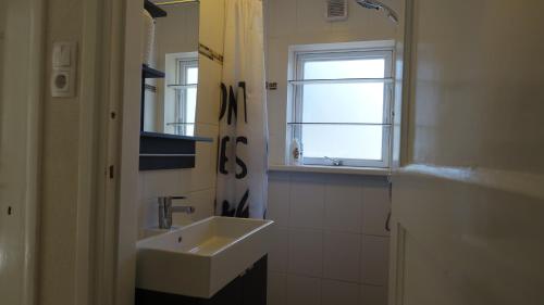a white bathroom with a sink and a window at The Holidayhouse in Loon op Zand
