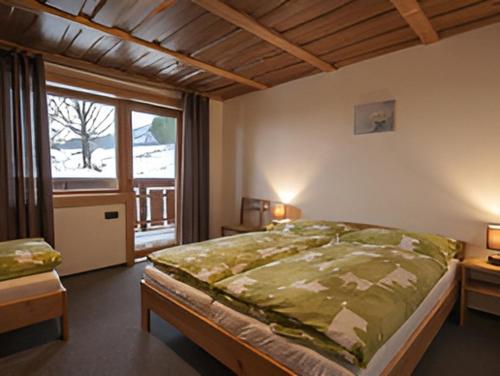 a bedroom with a large bed and a window at Podhradkom in Závažná Poruba