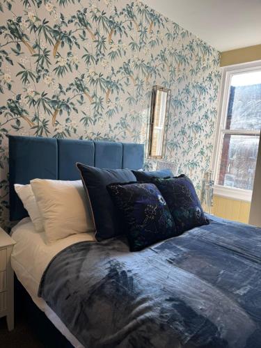 Schlafzimmer mit einem Bett mit blauem Kopfteil in der Unterkunft Apartment 2 at Blackburn Heights Sleeps 4 in Bridlington