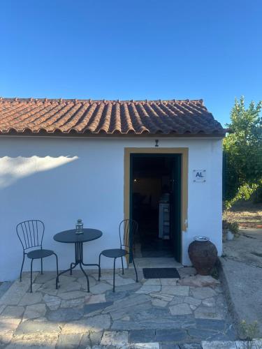un patio con tavolo e sedie di fronte a un edificio di A cozy cottage in Tomar a Tomar