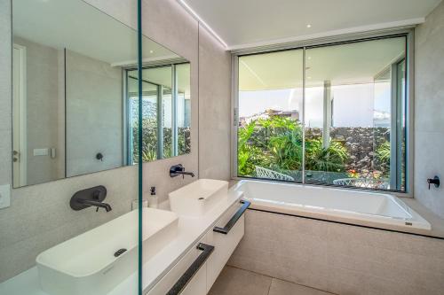 アデへにあるRocavista - Villa with heated rooftop pool and amazing ocean viewの浴槽と洗面台と窓のあるバスルーム