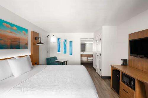 a hotel room with a bed and a flat screen tv at La Quinta Inn by Wyndham San Diego - Miramar in Sabre Springs