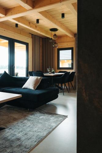 a living room with a couch and a table at Domki Osada Klenina SAUNA & BALIA in Kamienica