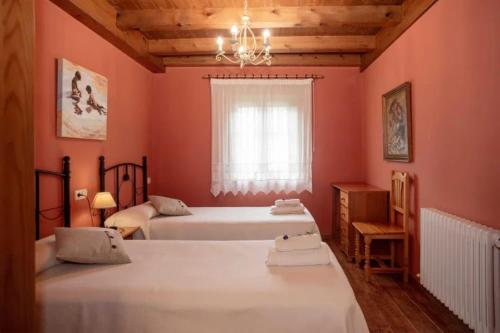 una camera da letto con due letti e una finestra di Casa rural Txorrota Txortako Txikia Selva de Irati a Orbaizeta