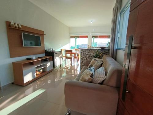 Una sala de estar con un sofá y un televisor. en Recanto da Serra, en Serra Negra