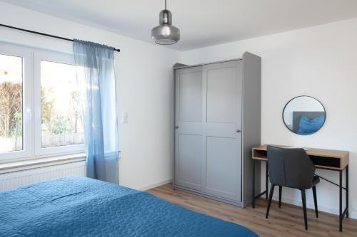 a bedroom with a bed and a desk and a mirror at Noahkis Apartments in Bad Ems