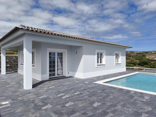 a white house with a swimming pool in front of it at Cantinho do alto in Porto Judeu