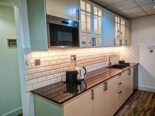 a kitchen counter with a sink and a microwave at La Buena Vida Holiday Homes - Modern, Luxe & Spacious 4-Bed, Full Kitchen, near to Beach, Tram & Marina in Dubai
