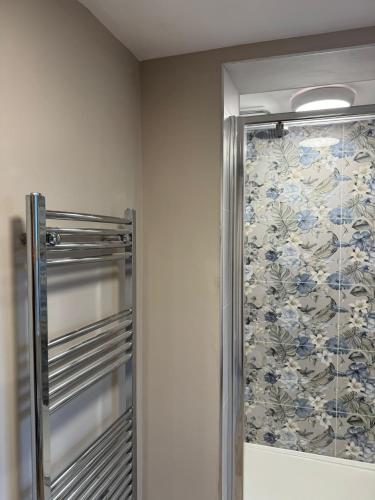 a shower in a bathroom with a floral shower curtain at Apartment 1 at Blackburn Heights Sleeps 2 in Bridlington