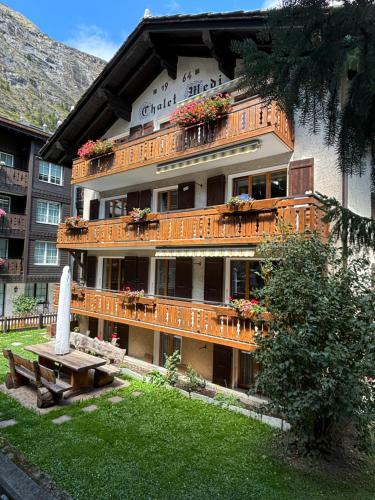 a building with a bench in front of it at Chalet Medi in Zermatt