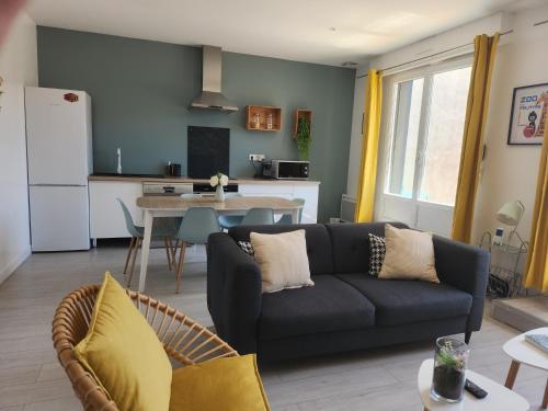 un soggiorno con divano e cucina di Le Cocon Marin a Saint-Georges-de-Didonne