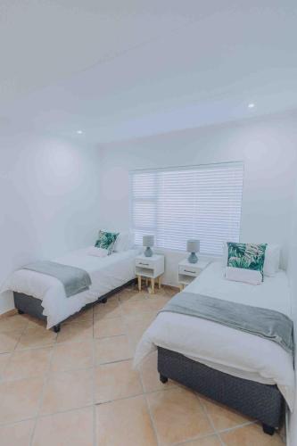 a bedroom with two beds and a window at Beach Penthouse in Mtwalume in Umtwalumi