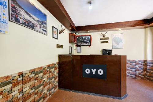 a sign on a reception desk in a room at Hotel O Tridev in Manāli