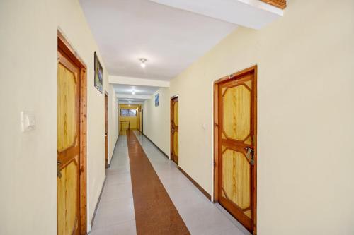 a corridor with two doors and a long hallway at Hotel O Tridev in Manāli