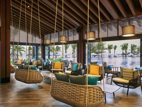 a lobby with chairs and a view of the water at Mövenpick Villas & Residences Phu Quoc in Phu Quoc