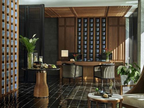 a lobby with a table and chairs and a wine cellar at Mövenpick Villas & Residences Phu Quoc in Phu Quoc