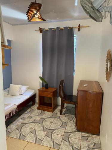 a bedroom with a bed and a chair and a table at La Posada - Hostel in Santa Teresa Beach