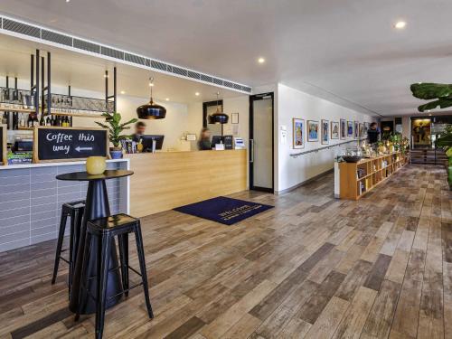 a restaurant with a bar and a counter with stools at Mercure Bendigo Schaller in Bendigo
