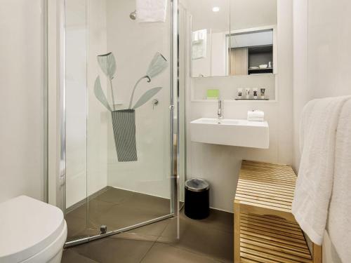 a bathroom with a shower and a toilet and a sink at Mercure Bendigo Schaller in Bendigo