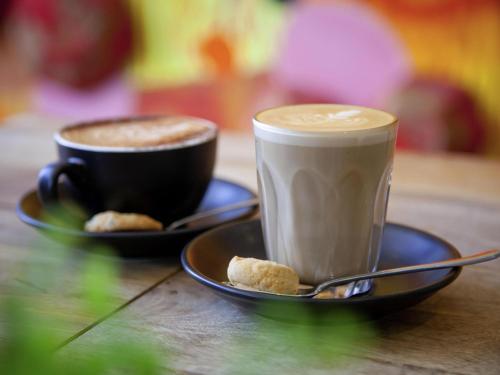 two cups of coffee and biscuits on a table at Mercure Bendigo Schaller in Bendigo