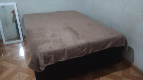 een bed in een kamer met een bruine deken bij Suíte por temporada in Belém