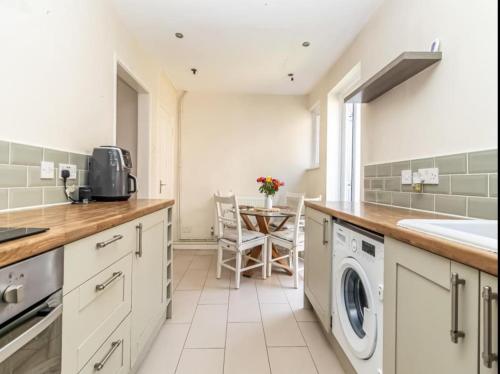 a kitchen with a sink and a dishwasher at Close to QA hospital, Portsmouth Naval Cottage with incredible views in Portsmouth