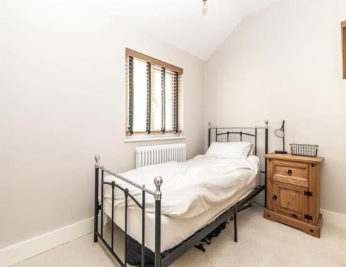 a bedroom with a bed and a nightstand and a window at Picturesque Naval Cottage with incredible views in Portsmouth