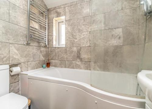 a bathroom with a tub and a toilet and a sink at Picturesque Naval Cottage with incredible views in Portsmouth