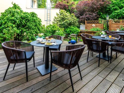 a patio with tables and chairs on a deck at Mercure Hotel Luebeck City Center in Lübeck