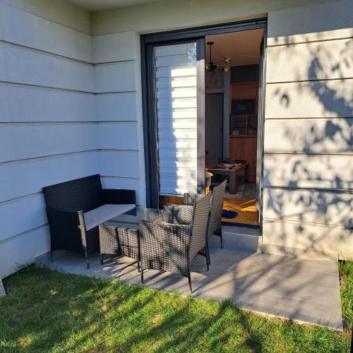 a patio with chairs and a table on a house at Ljubičica deluxe 2, sa dvorištem i parkingom in Vrnjačka Banja