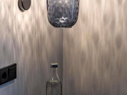 a glass bottle sitting on a table next to a lamp at Mercure Hotel Luebeck City Center in Lübeck