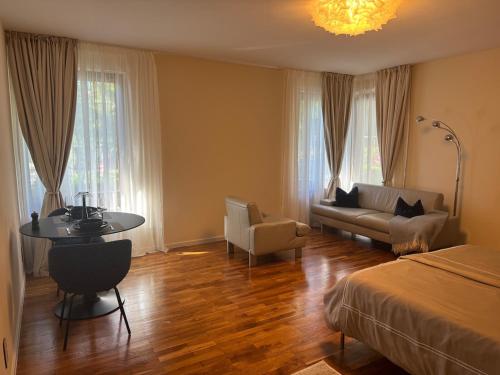 a bedroom with a bed and a table and a couch at 30 min from Munich & S-Bahn apartment with garden in Gauting