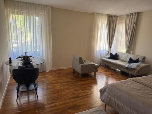 a bedroom with a bed and a table and a couch at 30 min from Munich & S-Bahn apartment with garden in Gauting